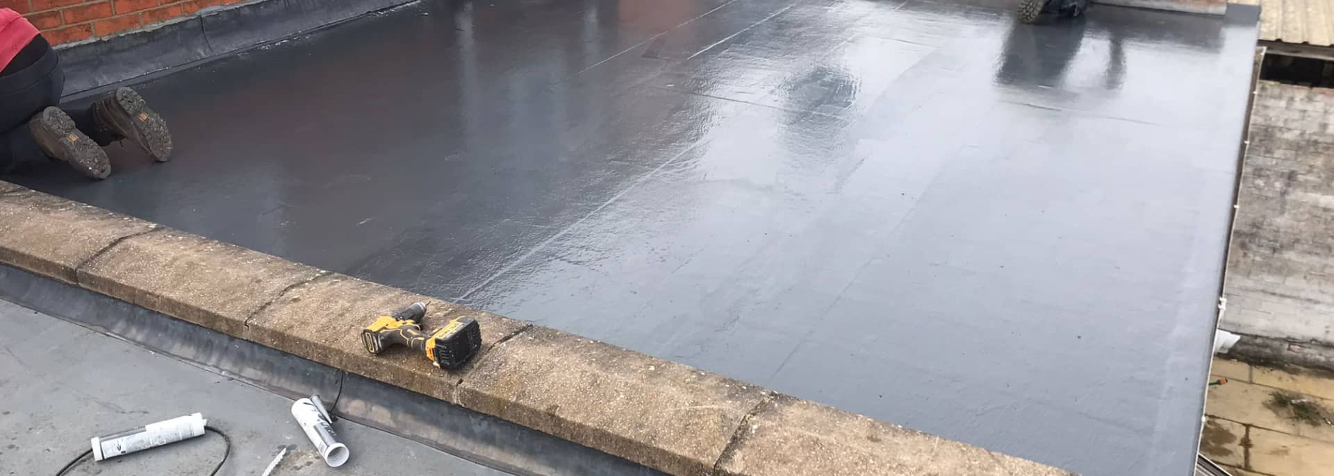 A GRP flat roof with tools and a drill on the coping, deck preparation by GMG Roof Experts in Hillingdon