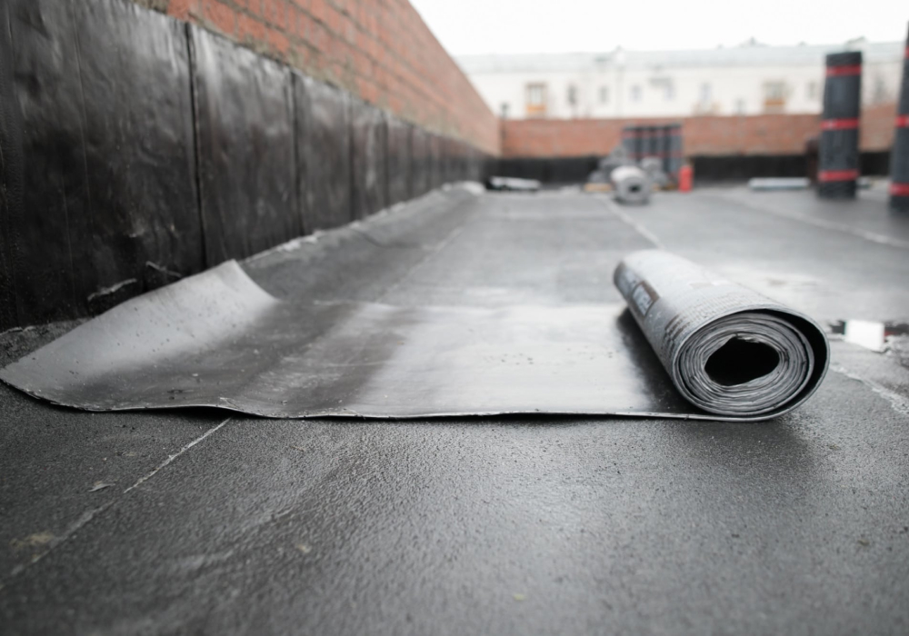 A roll of EPDM rubber membrane on a prepared flat roof, used by GMG Roof Experts in the Hillingdon area