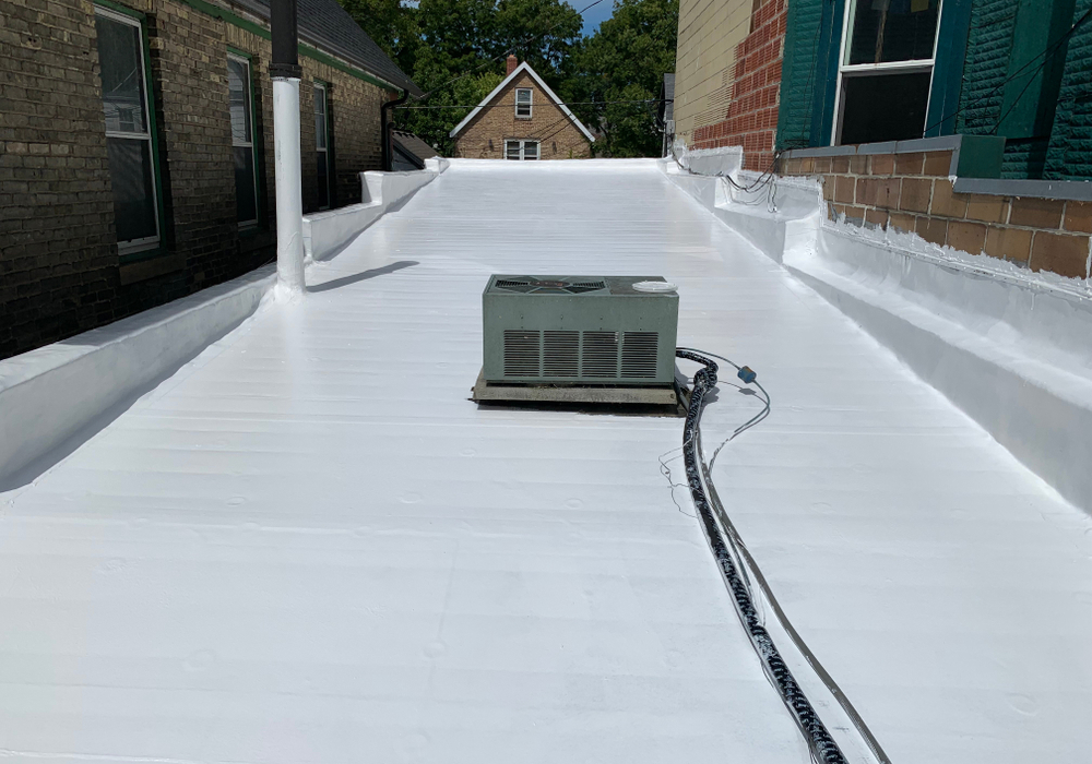 A white liquid roof coating applied to a flat roof by GMG Roof Experts in the Hillingdon area