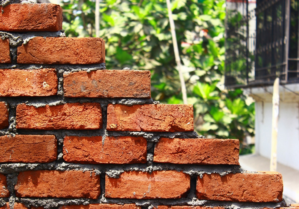 A stepped section of new brickwork with fresh mortar joints, by GMG Roof Experts in the Hillingdon area