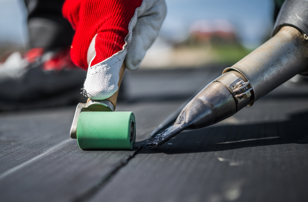 GMG Roof Experts bonding an EPDM rubber membrane on a flat roof, serving Hillingdon and West London