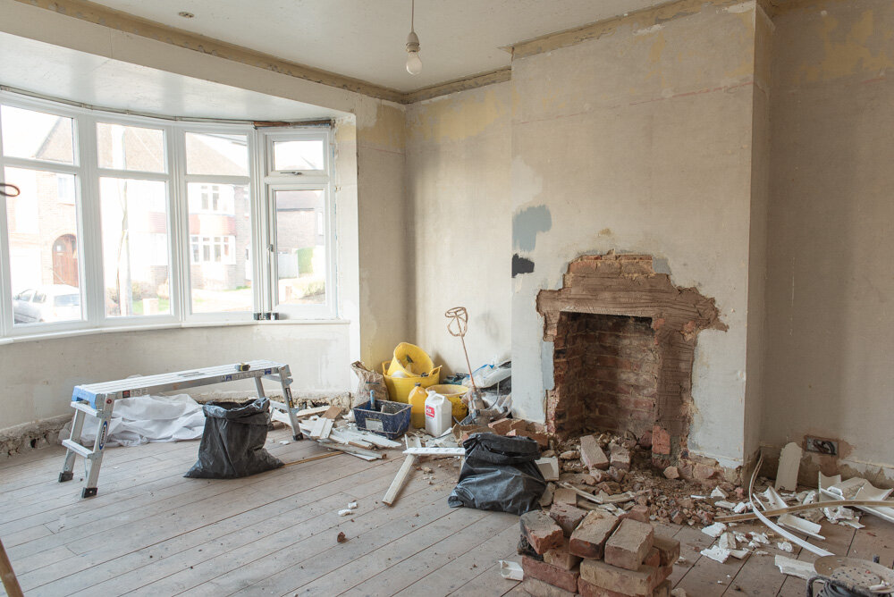 A chimney breast opened up for repair inside a stripped room, by GMG Roof Experts in the Hillingdon area