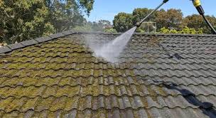 Low-pressure water clearing algae and moss from a tiled roof, roof cleaning by GMG Roof Experts in the Hillingdon area