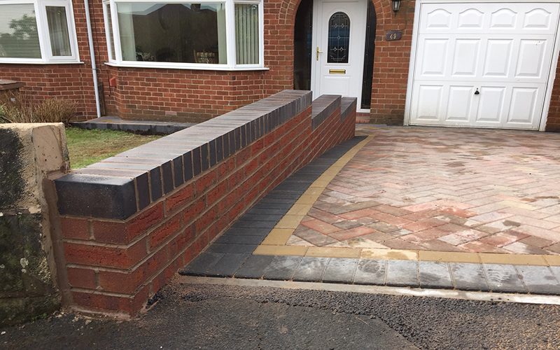 A low red brick front wall with engineering brick coping, built by GMG Roof Experts in Hillingdon