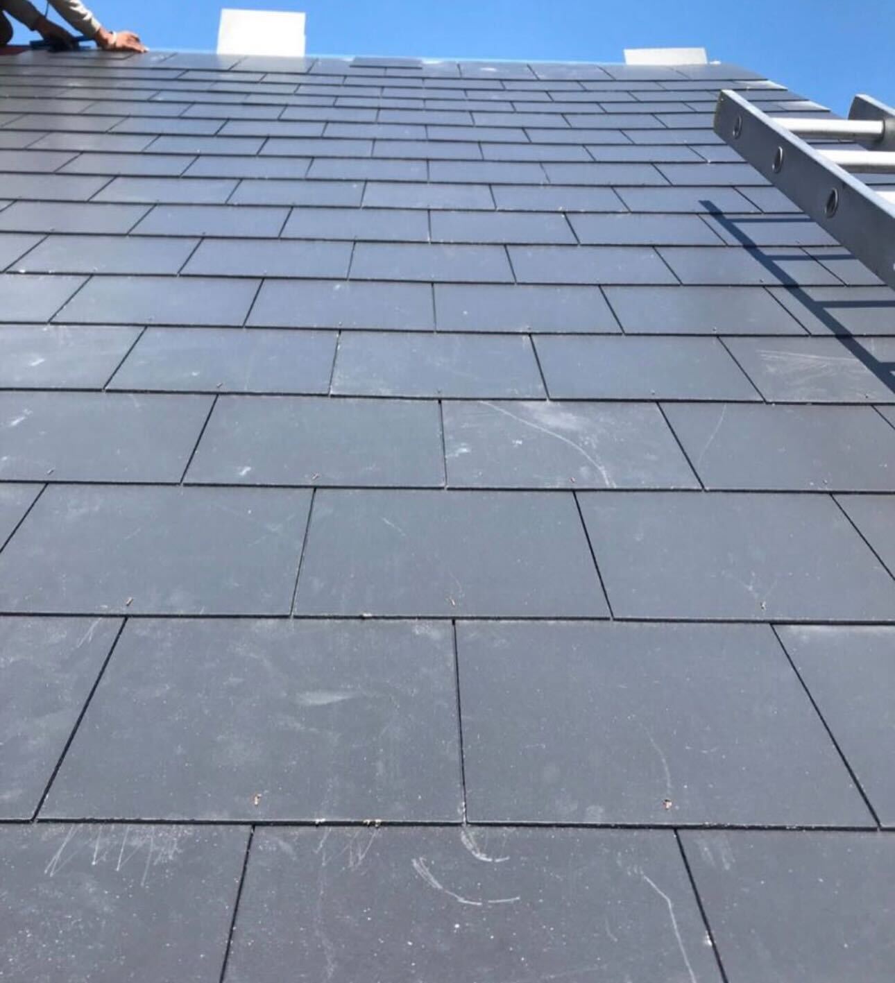 A freshly re-covered roof slope against a blue sky by GMG Roof Experts in Hillingdon